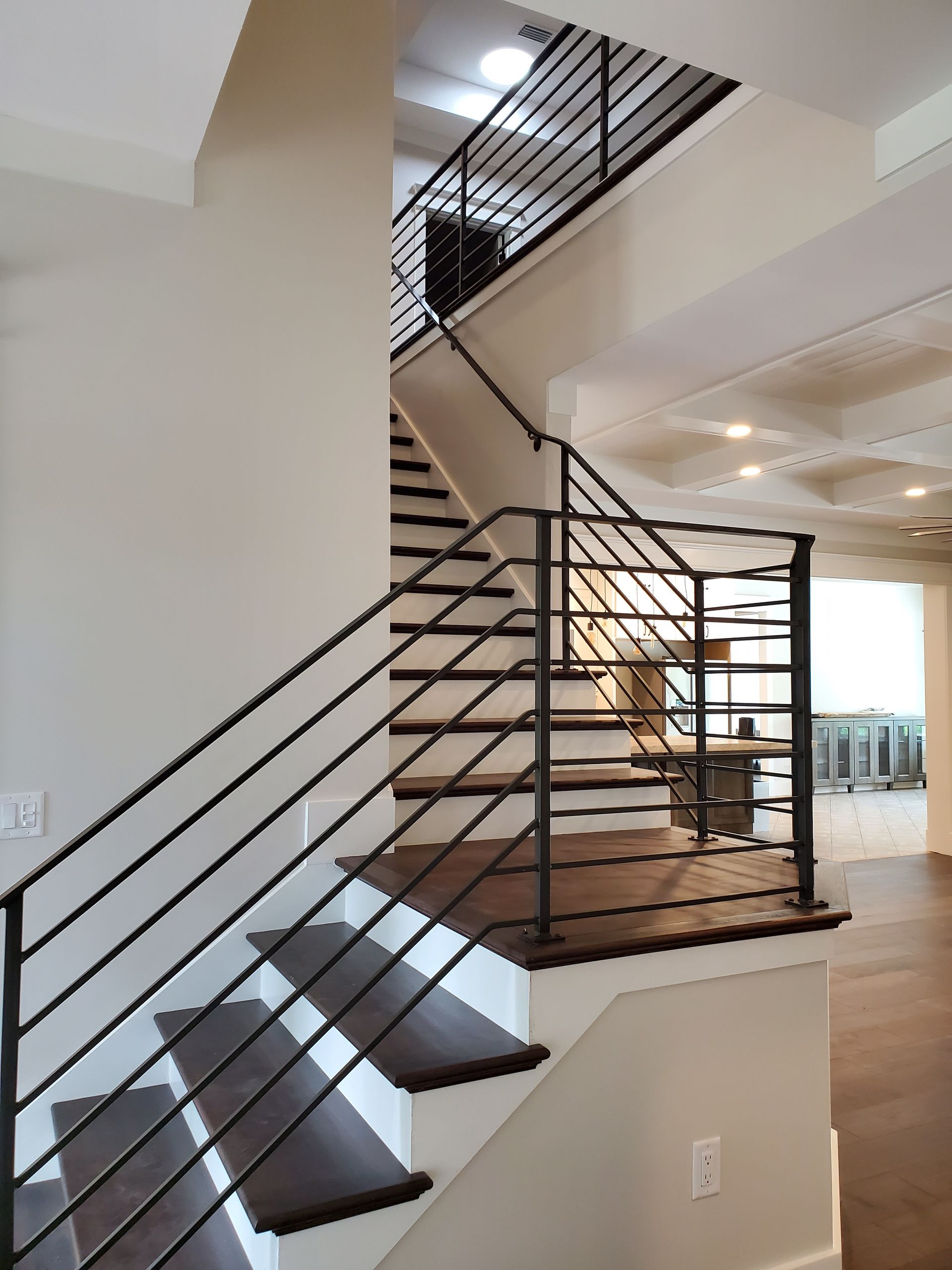 A staircase in a house with a black railing