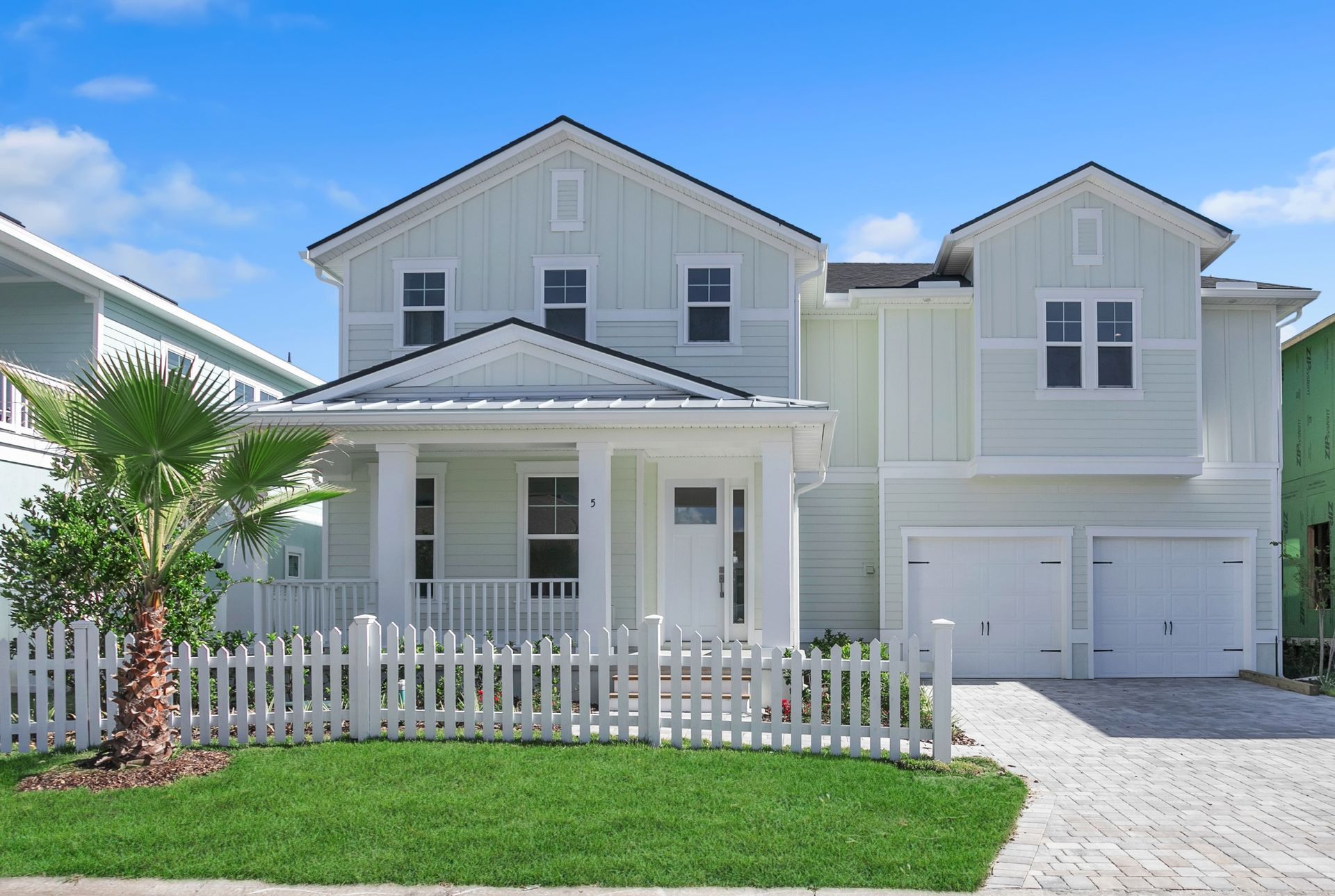 A white house with a white picket fence in front of it