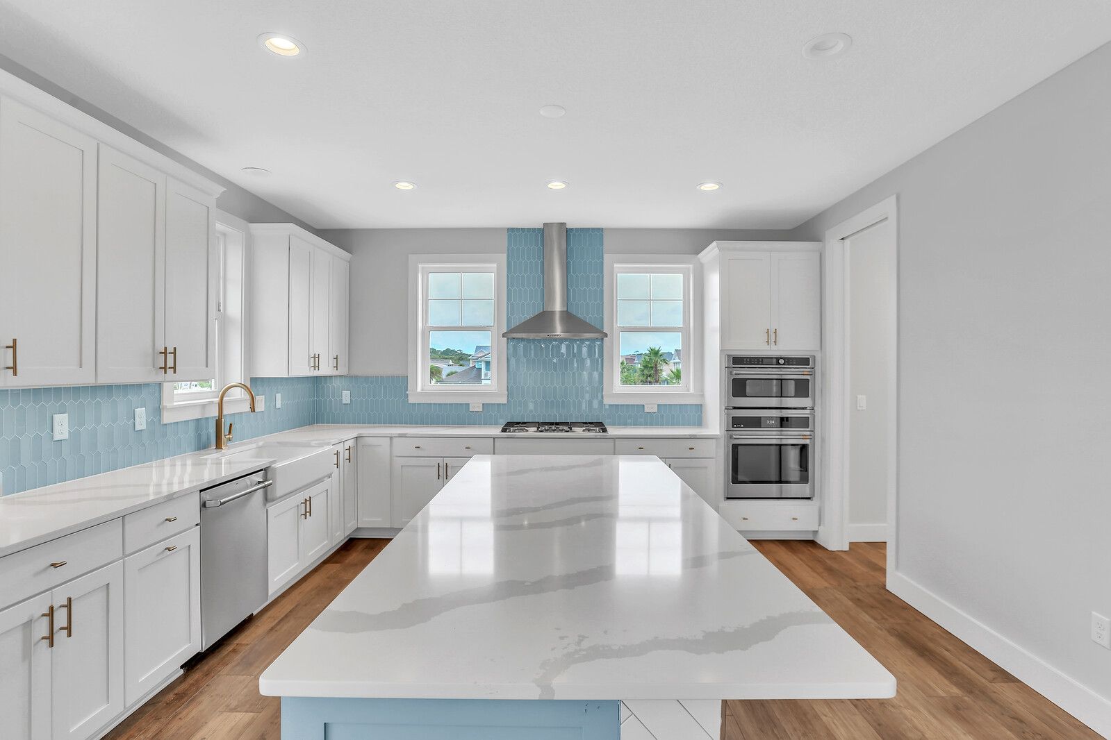 A kitchen with white cabinets and a large island in the middle