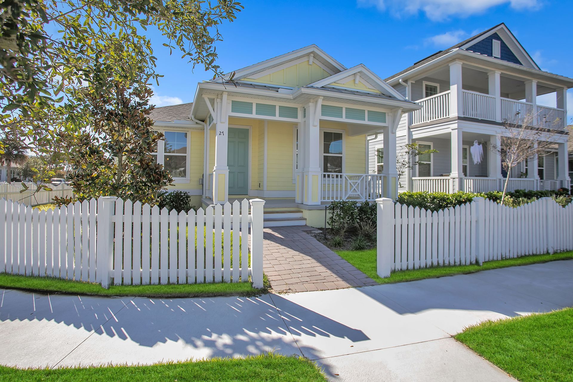 A yellow house with a white picket fence in front of it