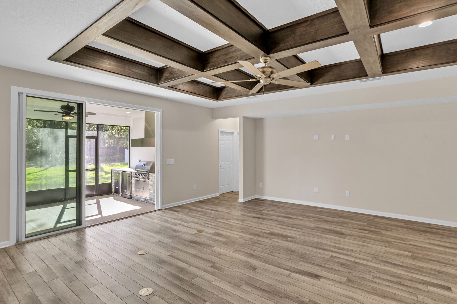An empty living room with hardwood floors and a ceiling fan.