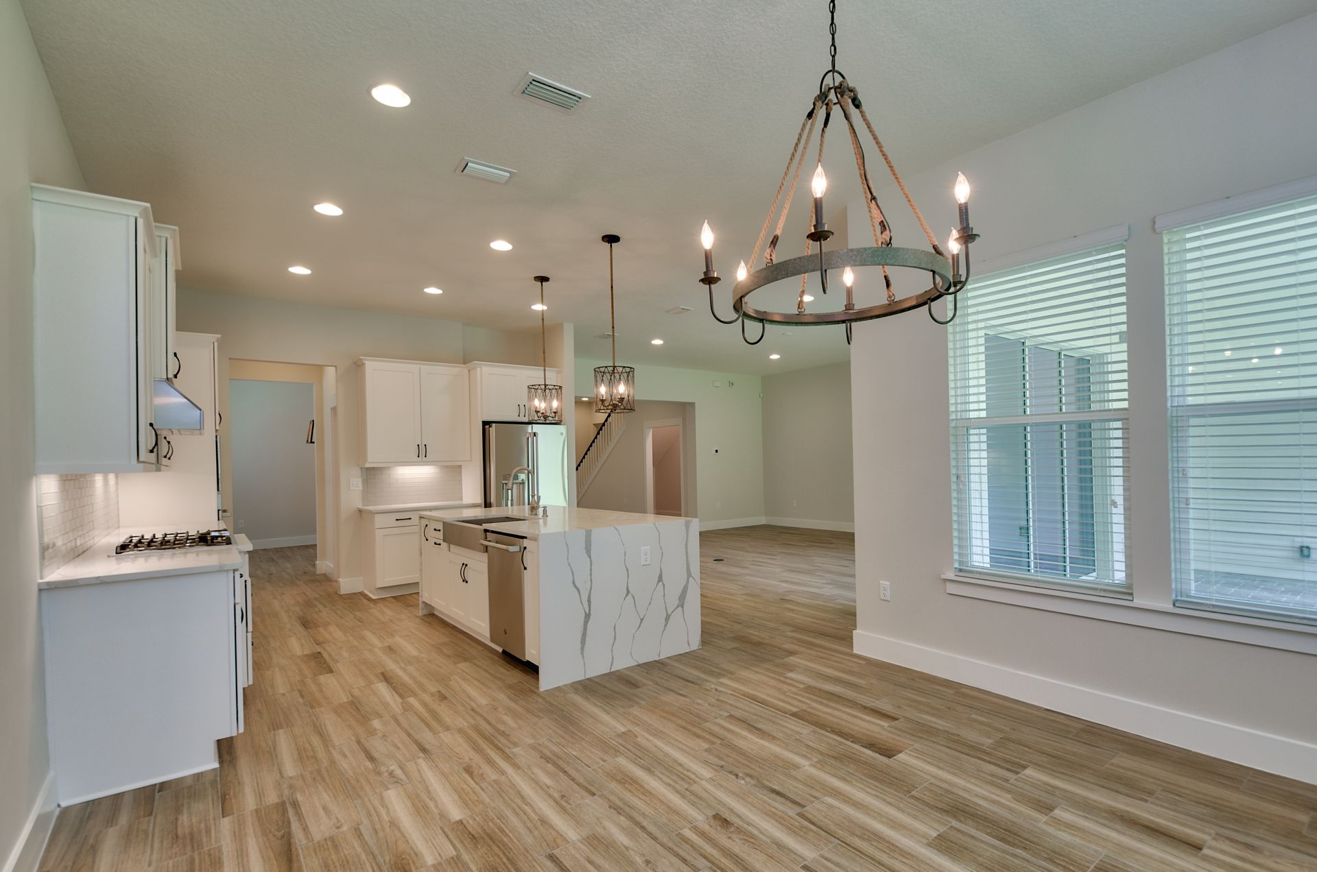 There is a chandelier hanging from the ceiling in the kitchen.