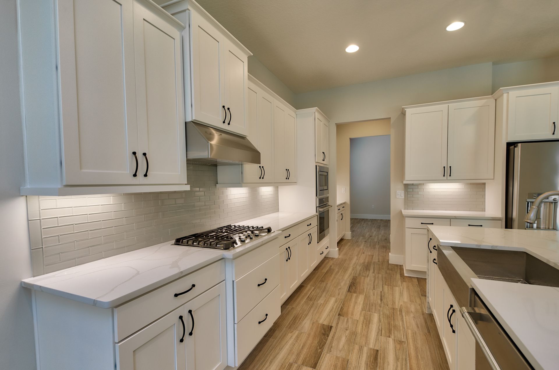 A kitchen with white cabinets and stainless steel appliances