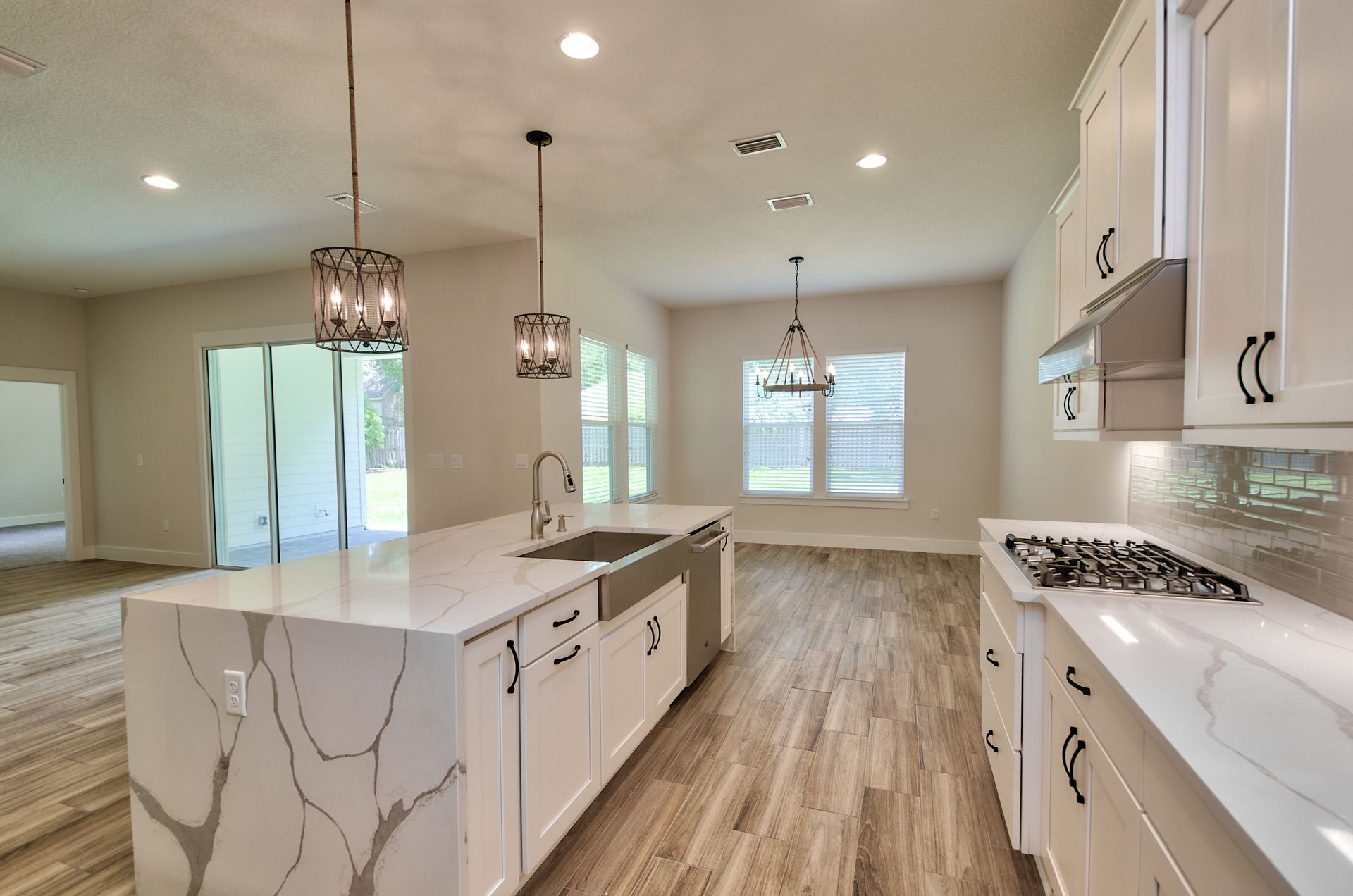 A kitchen with white cabinets and a large island in the middle.