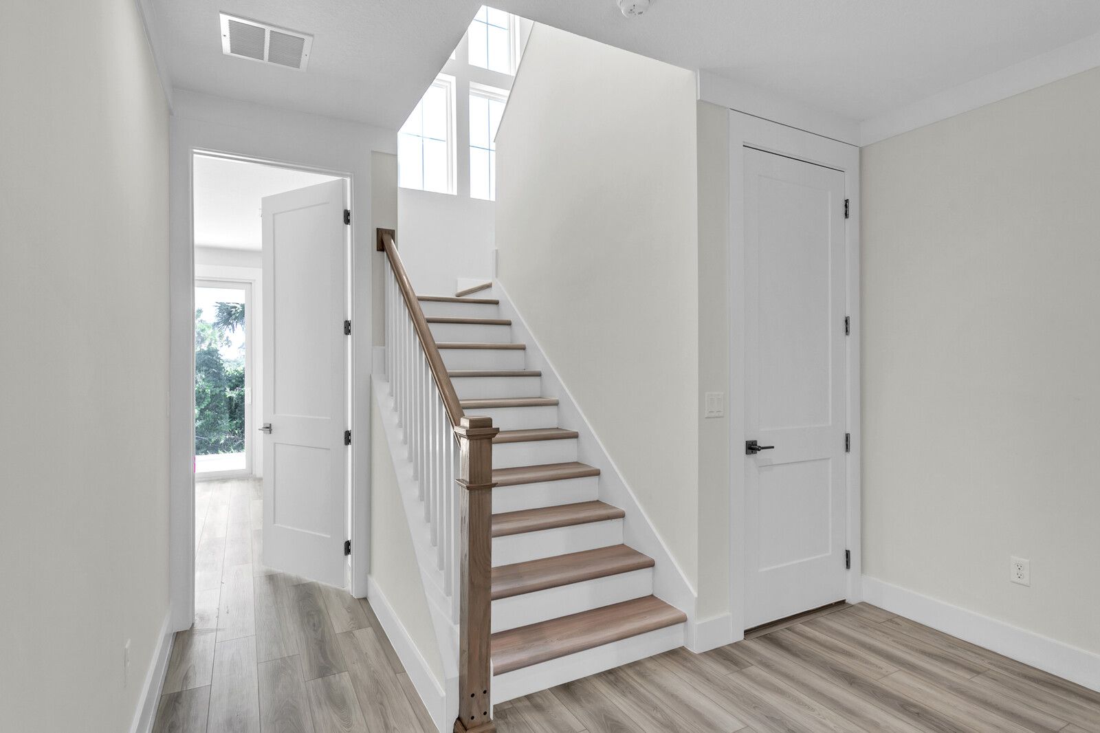 A hallway with stairs leading up to the second floor of a house.