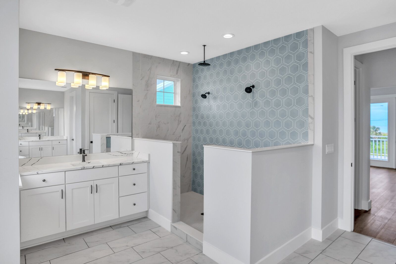 A bathroom with two sinks and a walk in shower.