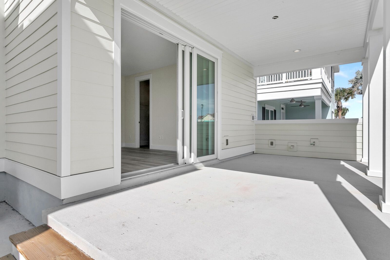 A white house with a large sliding glass door.