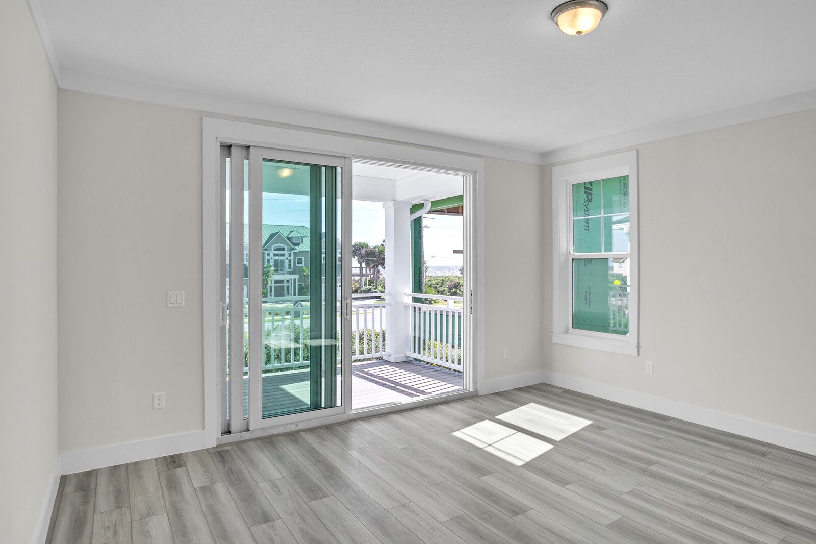 An empty room with sliding glass doors leading to a balcony.