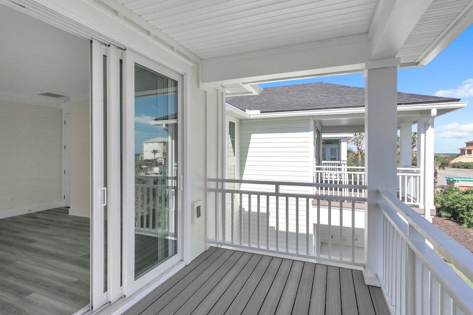 There is a balcony with a sliding glass door and a railing.