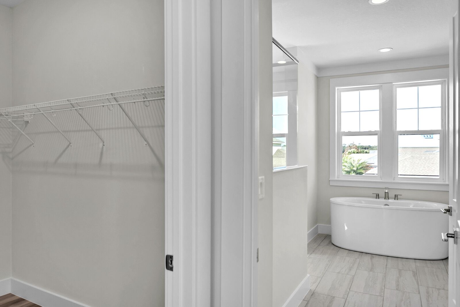 A bathroom with a bathtub and a walk in closet.