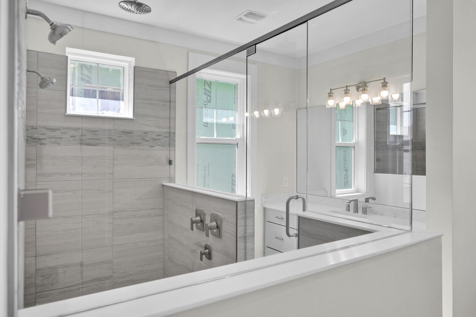 A bathroom with a walk in shower and a window.