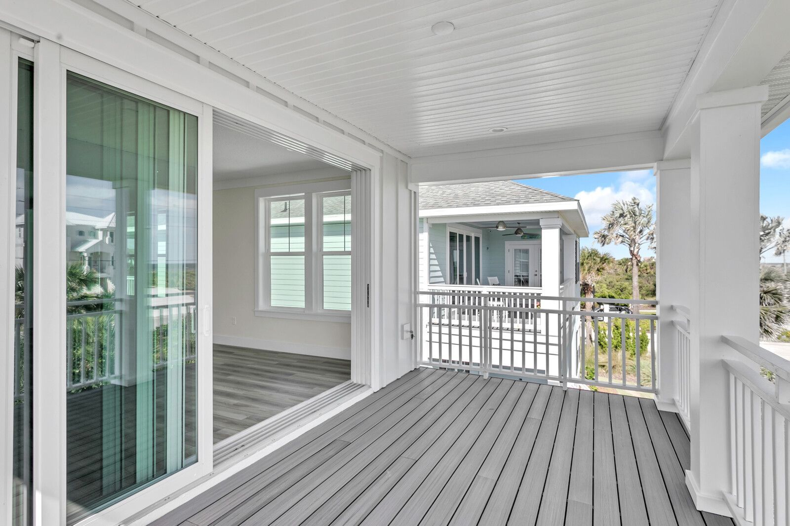 A large porch with sliding glass doors and a railing.