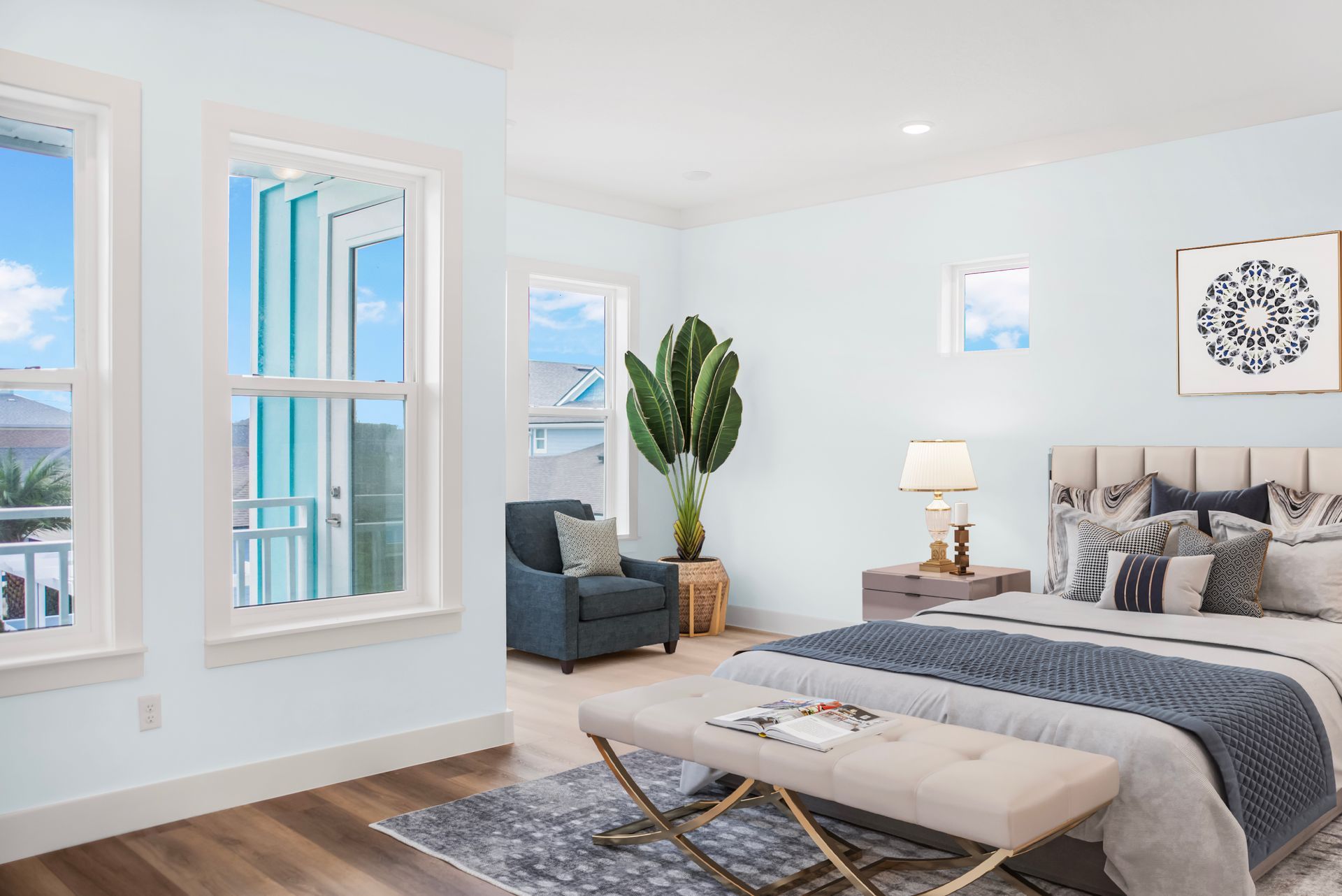 A bedroom with a bed , chair , bench and windows.
