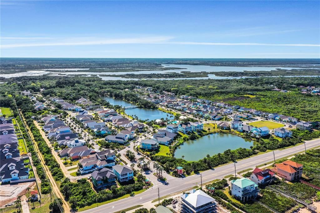 An aerial view of a residential area with lots of houses and ponds.
