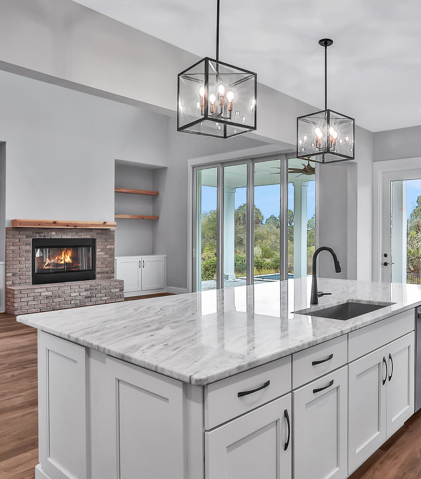 A kitchen with white cabinets and marble counter tops