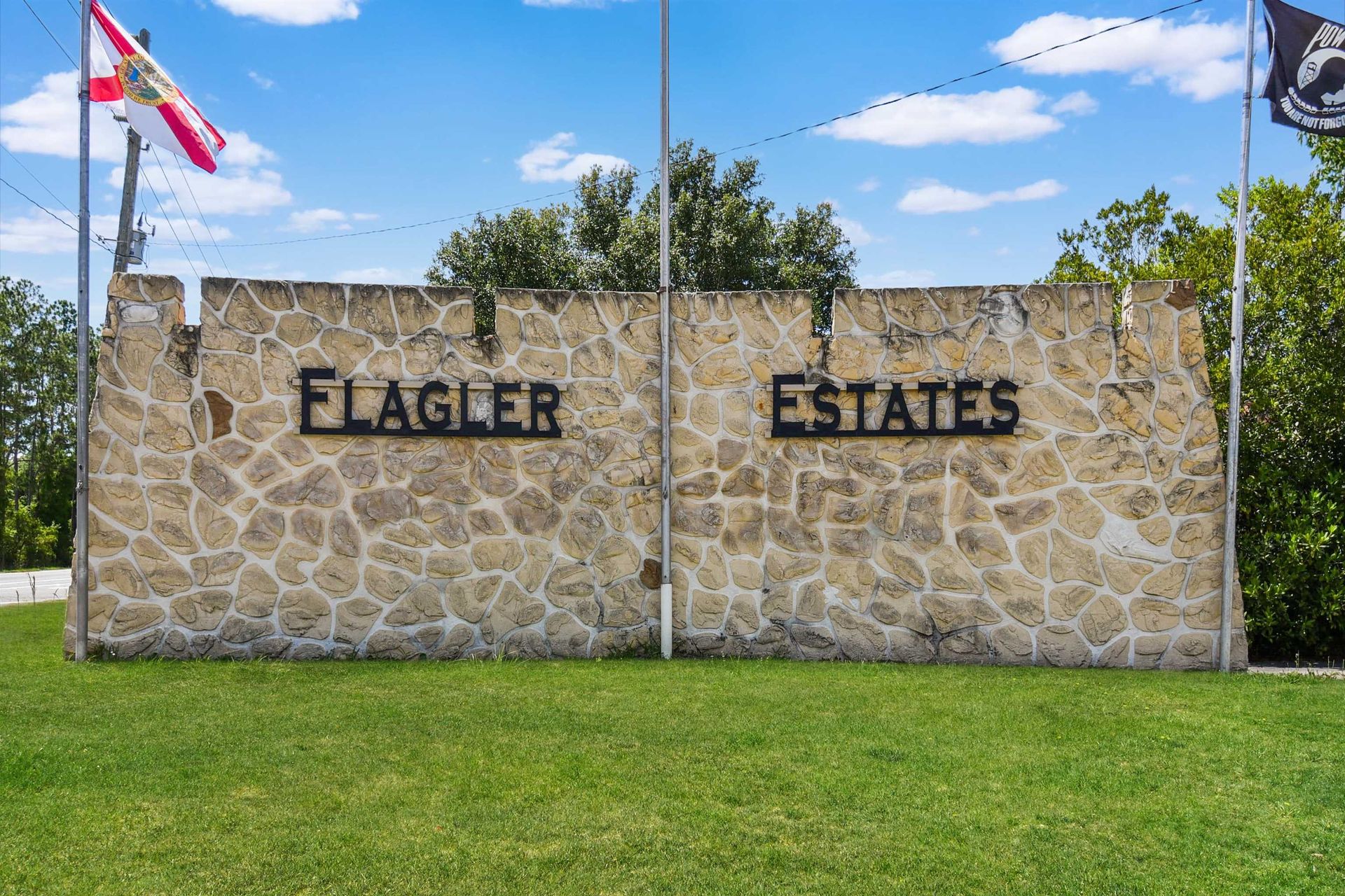 A stone wall with the words flagler estates written on it