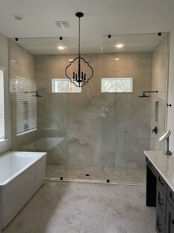 A bathroom with a walk in shower and a bathtub.
