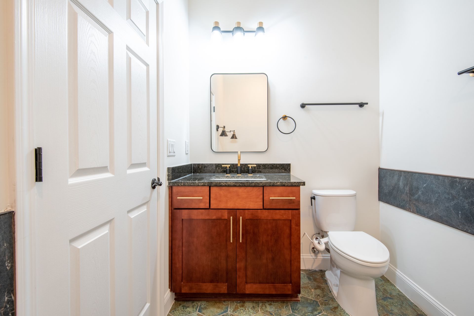 A bathroom with a toilet , sink and mirror.