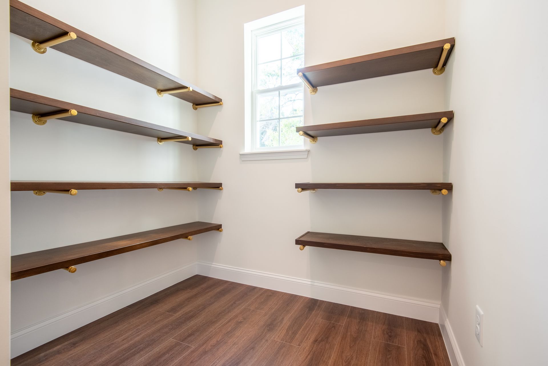 A small room with wooden shelves and a window.