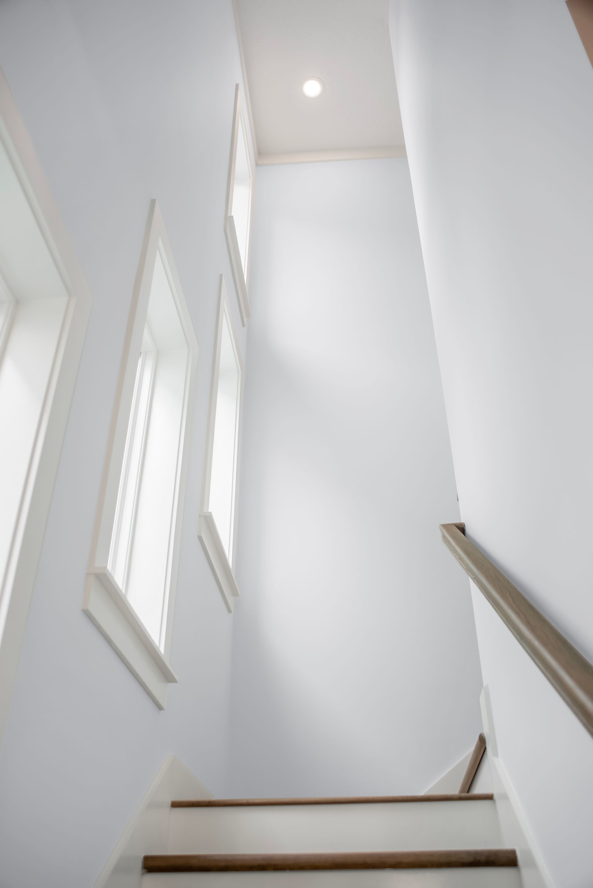 A staircase with white walls and wooden steps