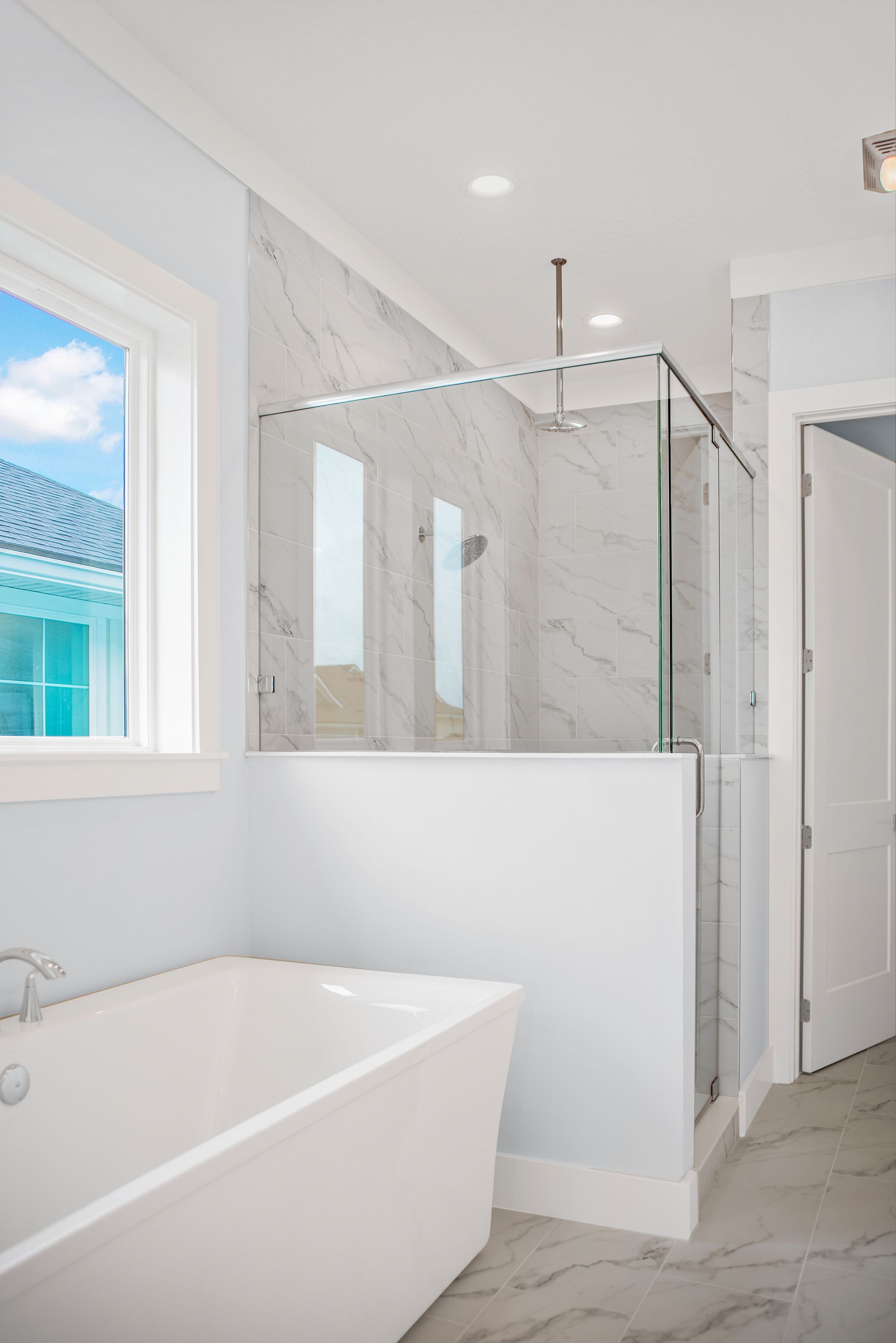 A bathroom with a tub and a walk in shower.