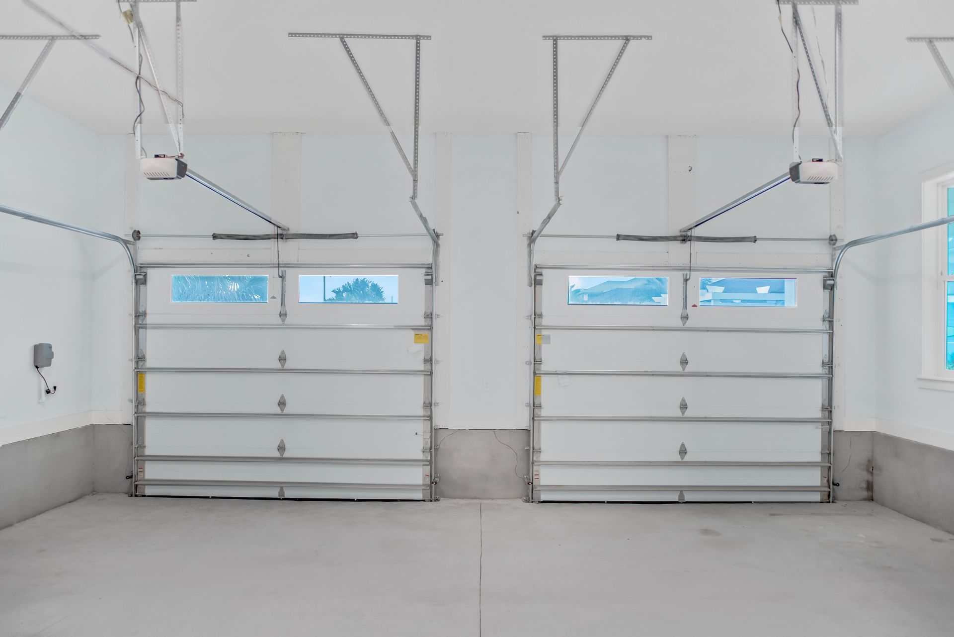 There are two garage doors open in a garage.