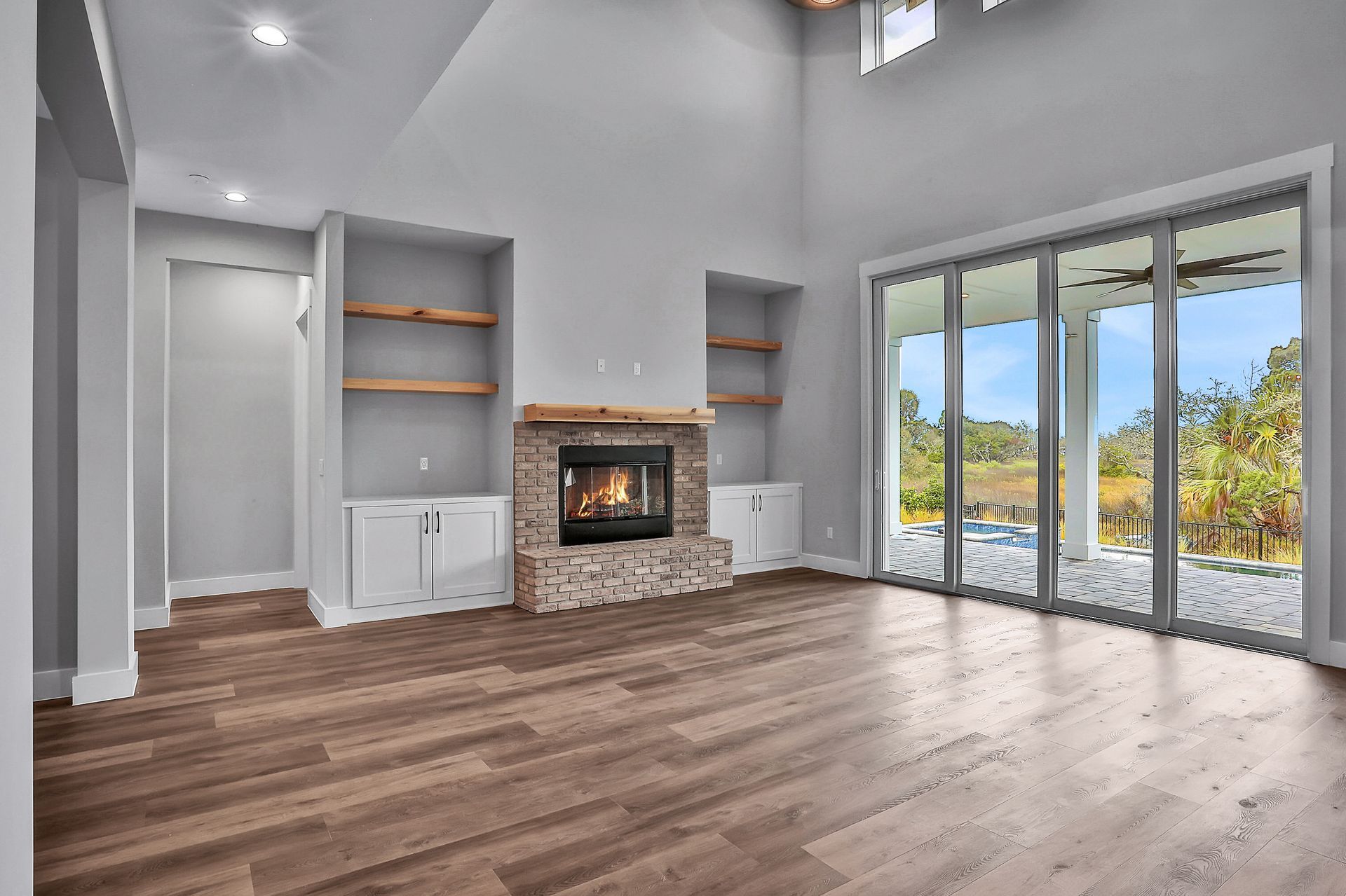 An empty living room with hardwood floors and a fireplace.