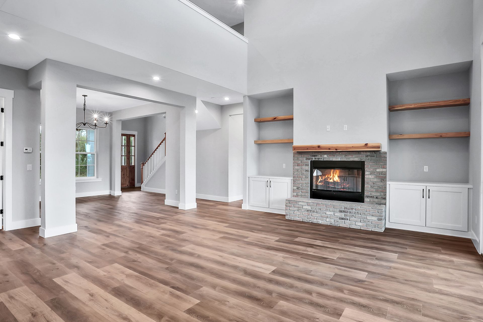An empty living room with hardwood floors and a fireplace.