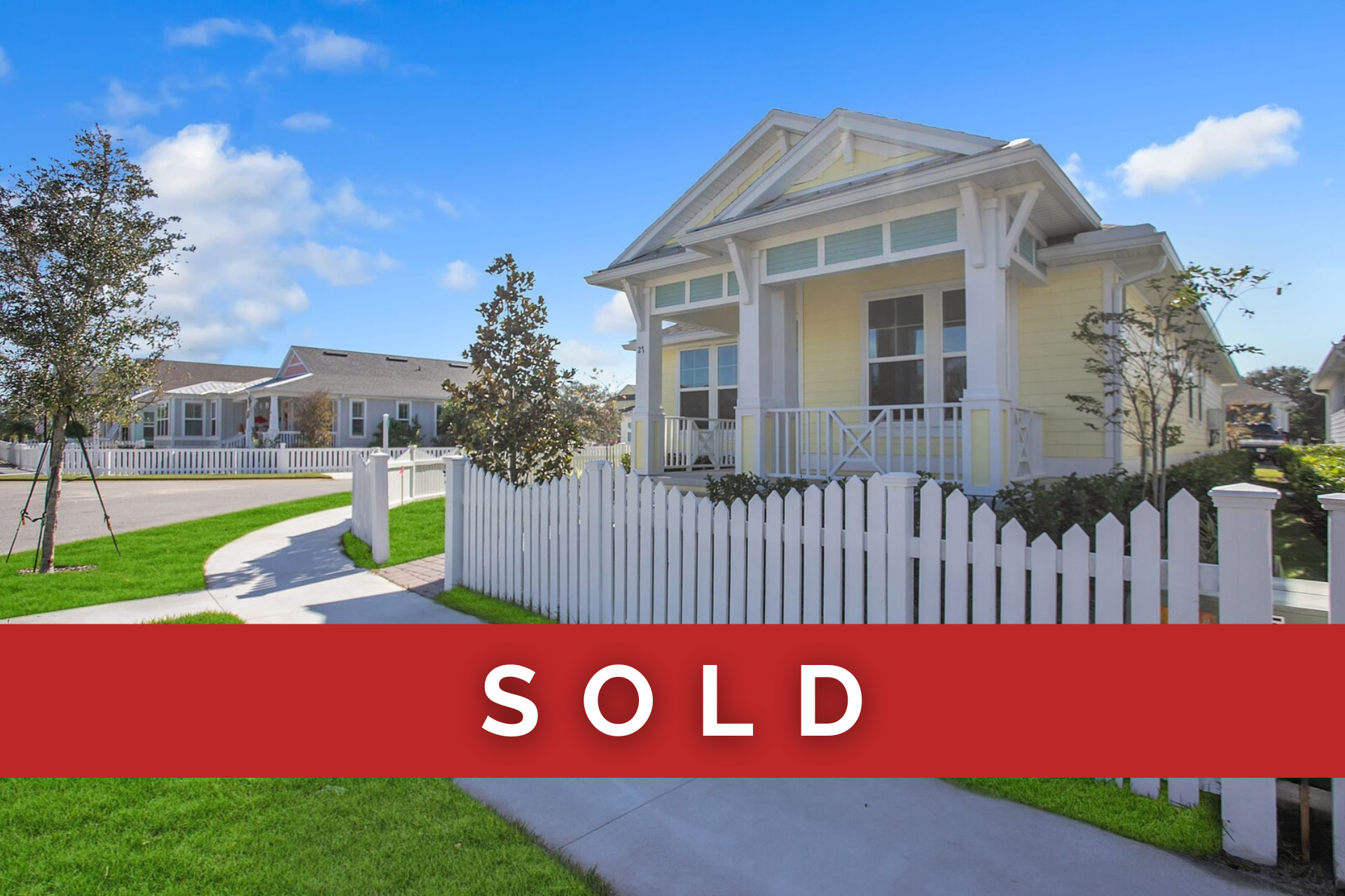 A yellow house with a white picket fence has been sold