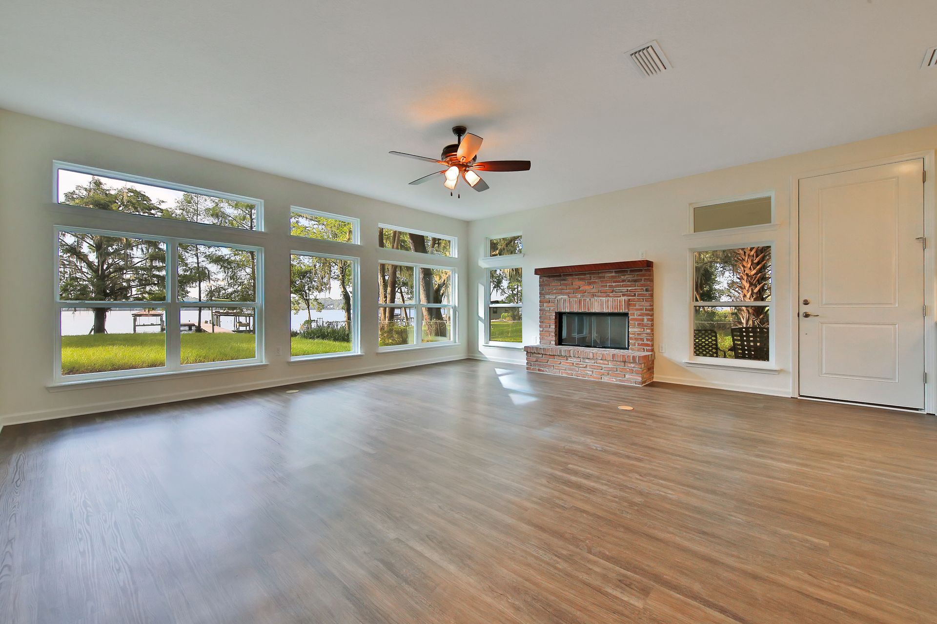 An empty living room with hardwood floors and a fireplace.