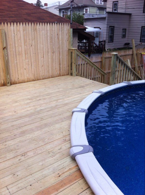 Wooden deck next to an above-ground swimming pool. 