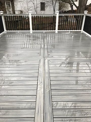 Wet gray deck with black and white railings.
