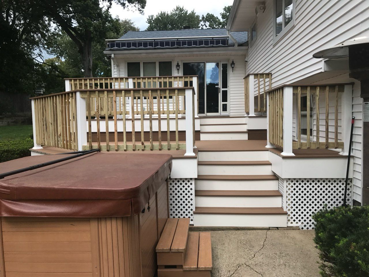 Wooden deck with steps leading to a house.