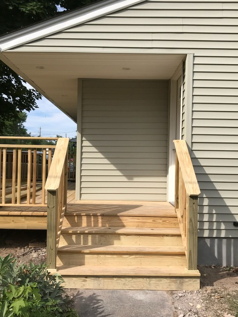 Wooden steps leading to a door with a covered entrance.