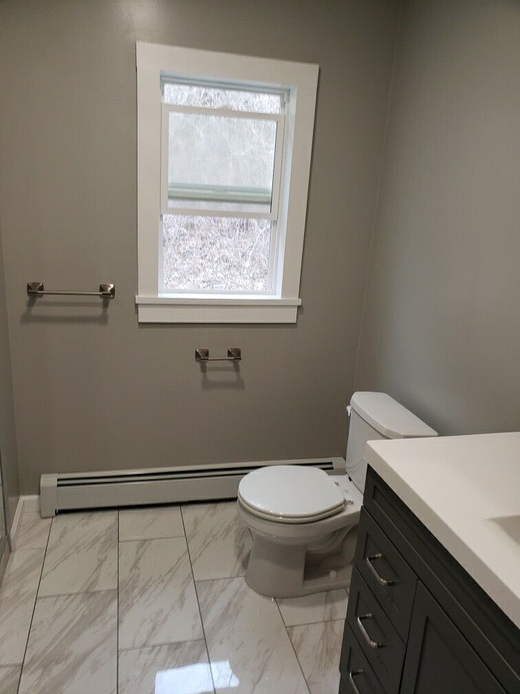 Bathroom with gray walls, white trim, a toilet, and a vanity.