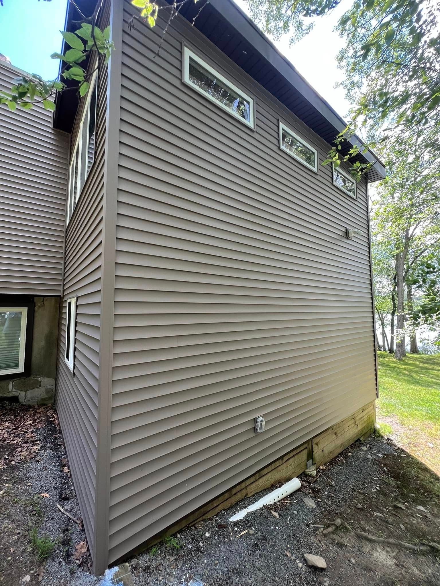 Brown sided house with small rectangular windows.