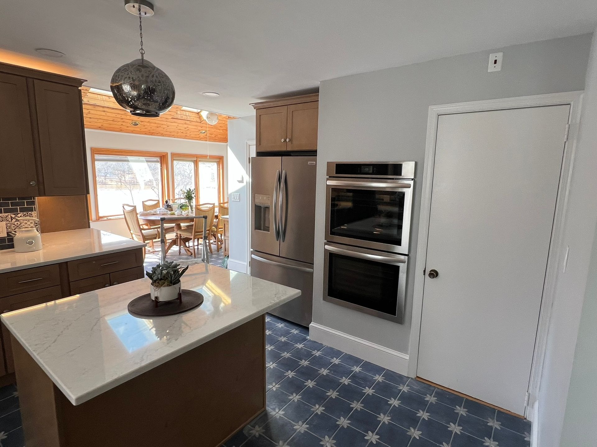 Kitchen with island, stainless steel appliances, and a dining area in the background.