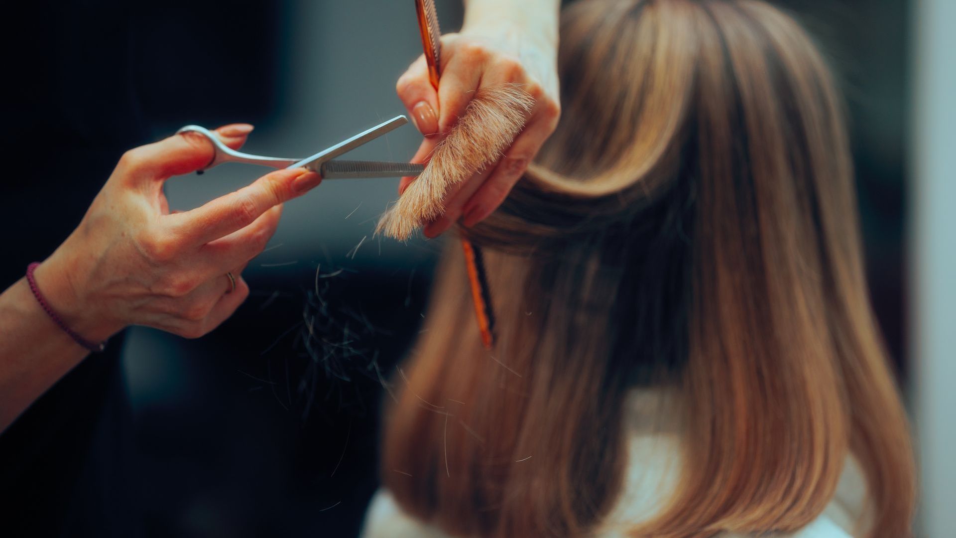 Woman in green dress holds book, standing on red carpet at 