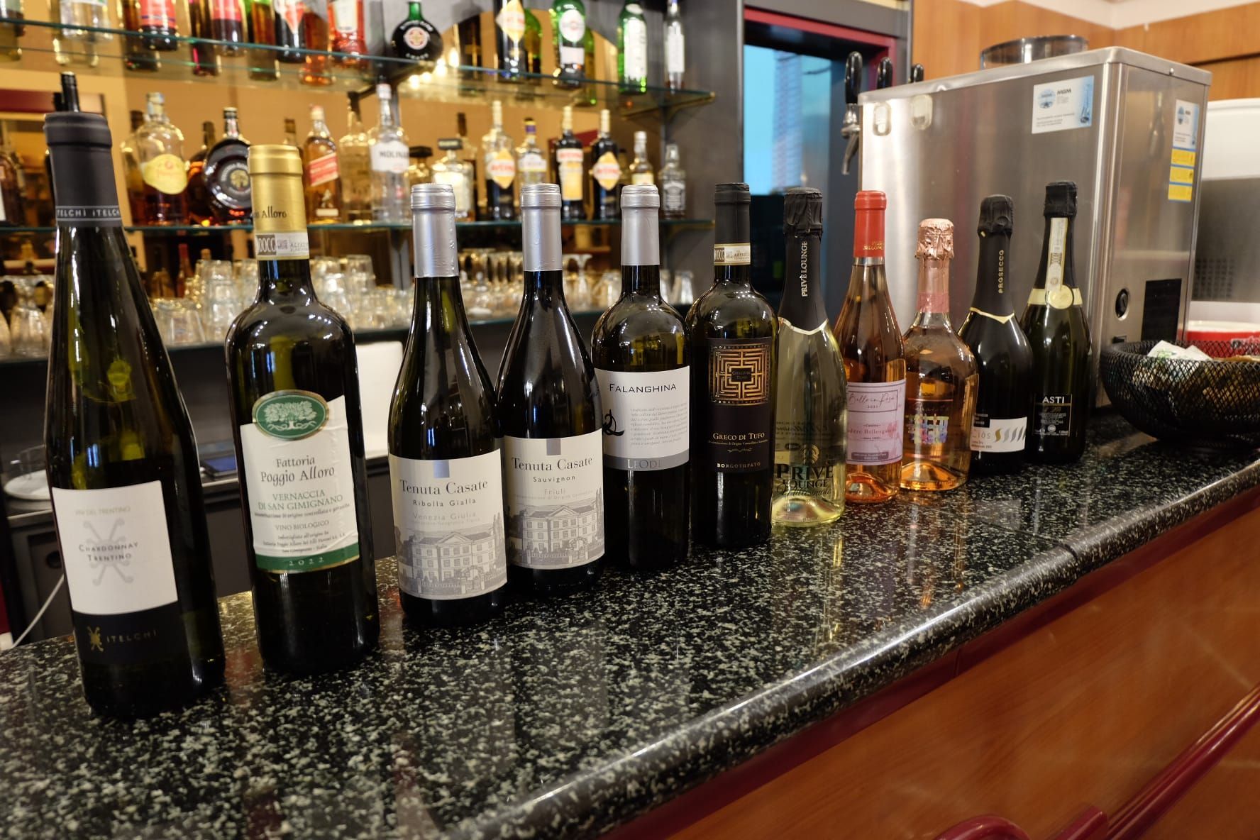 molte bottiglie di vino sono sedute su un bancone