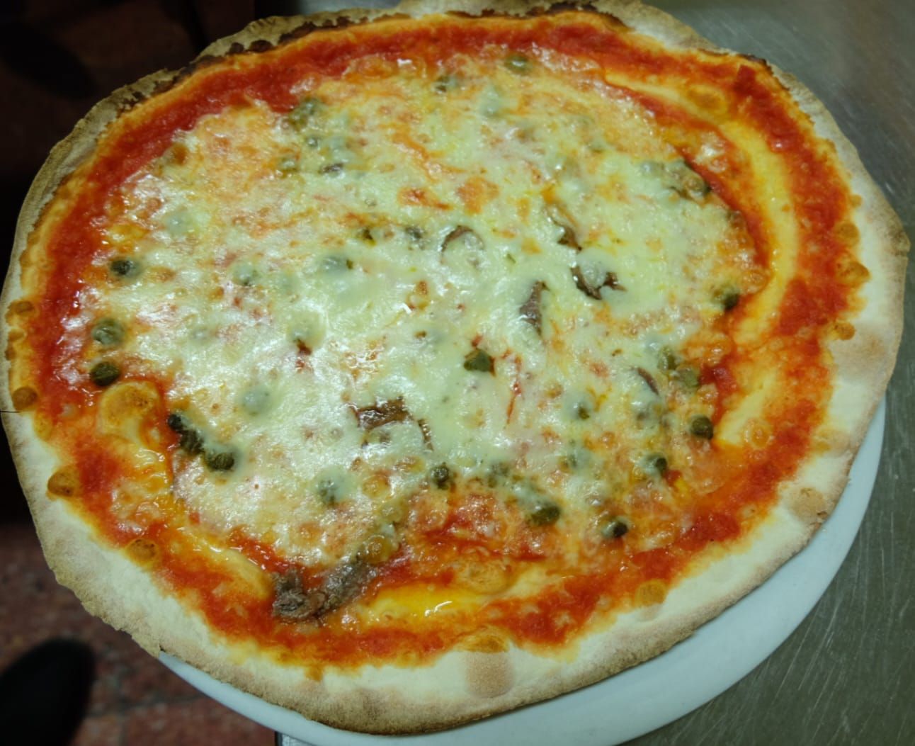 un primo piano di una pizza su un piatto bianco