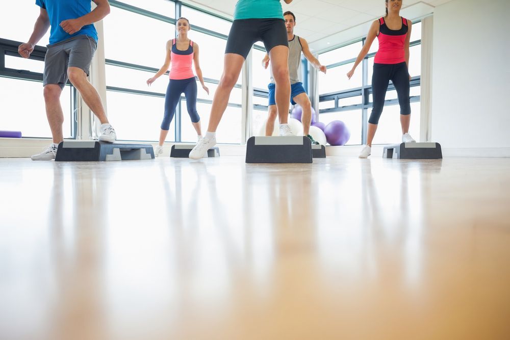 A Group Of People Are Doing Step Aerobics In A Gym — Sandy Gugenberger Podiatrist in Port Macquarie, NSW