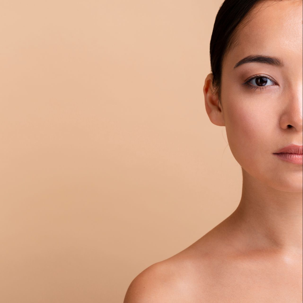 half of a woman 's face is shown against a beige background  at Lush Aesthetics Med Spa
