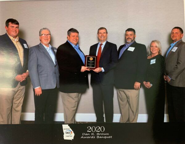 A group of people standing next to each other holding a plaque.