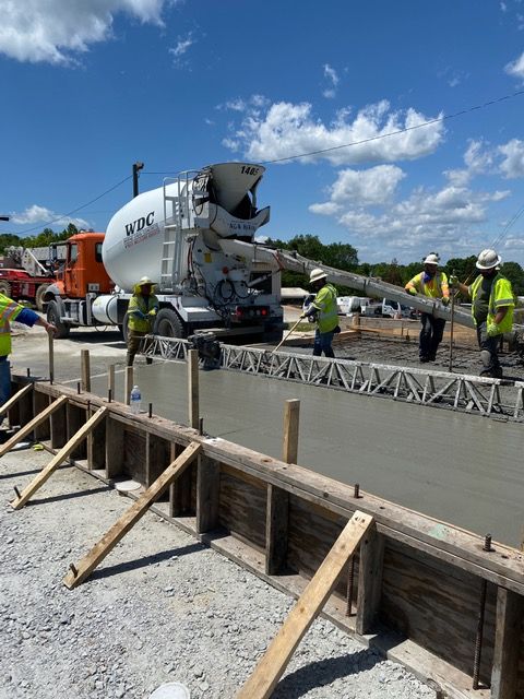 A concrete truck is pouring concrete on a construction site