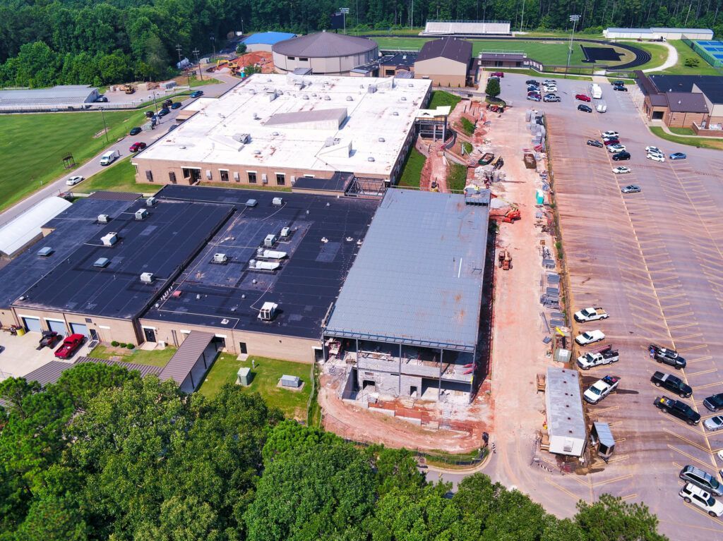 An aerial view of a large building with a lot of cars parked in front of it