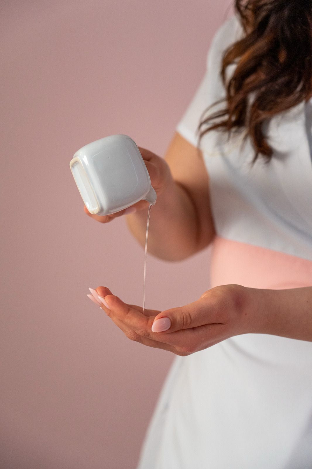 Una donna si versa del liquido nella mano.