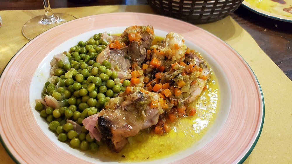 Piatto con piselli e carne in salsa su un piatto dal bordo rosa.
