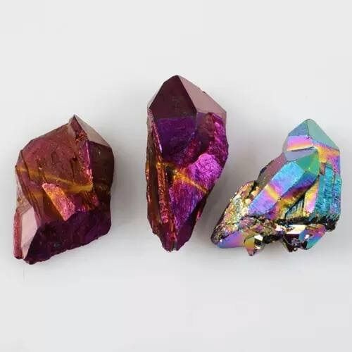 Three iridescent crystals with purple, pink, and blue hues.
