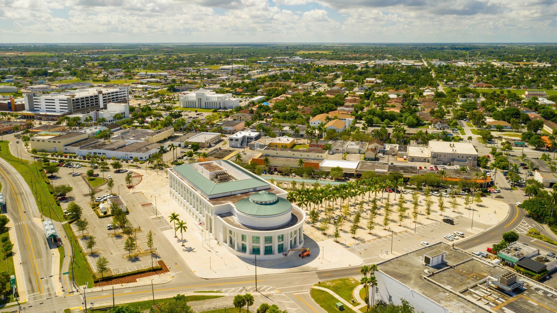 Aerial view of a city with a large, white building in the foreground