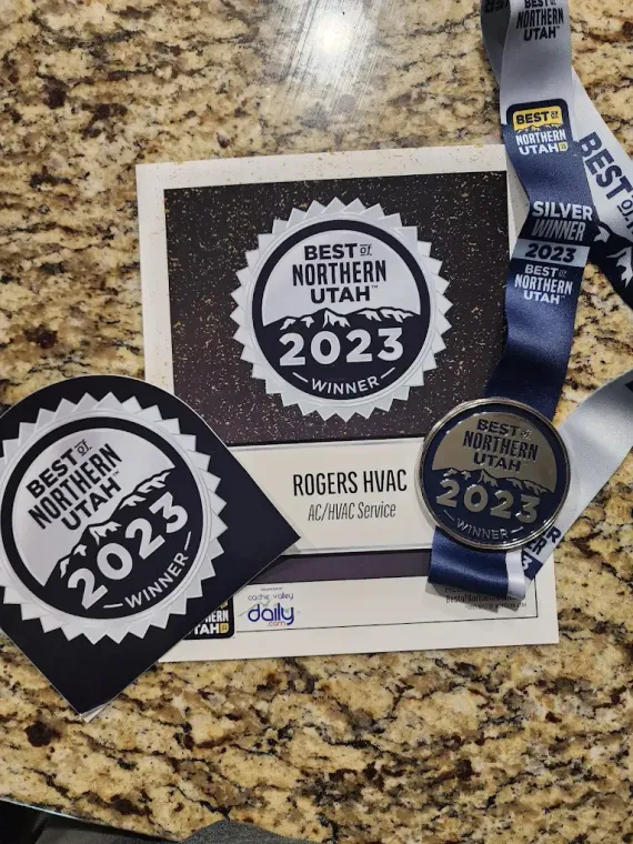 A medal is sitting on top of a table next to a certificate.